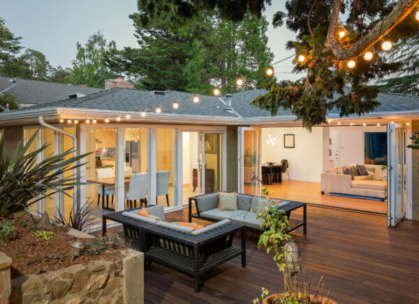 Home with furniture patio / wooden deck at twilight.