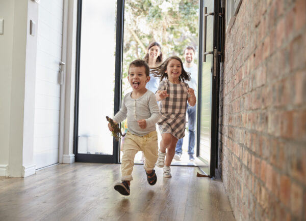 Excited Children Arriving Home With Parents